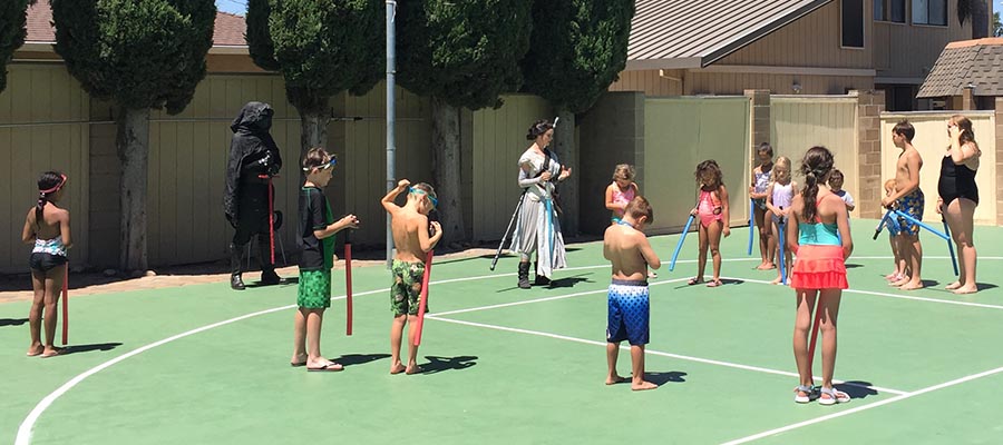kids playing star wars on the basketball court for the birthday party