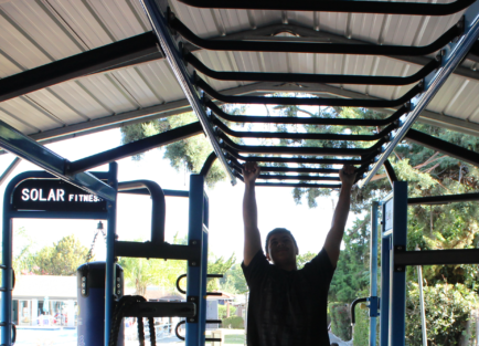 Person climbing monkey-bars