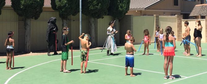 kids playing star wars on the basketball court for the birthday party