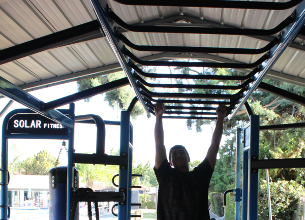 a man doing a money bar at the cross functional fitness station