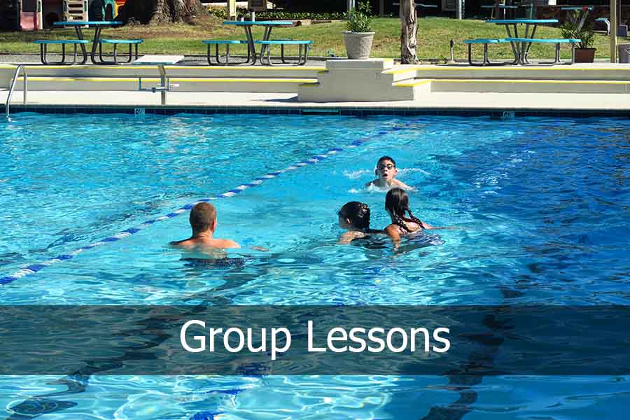 swim instructor teaching group of kids.