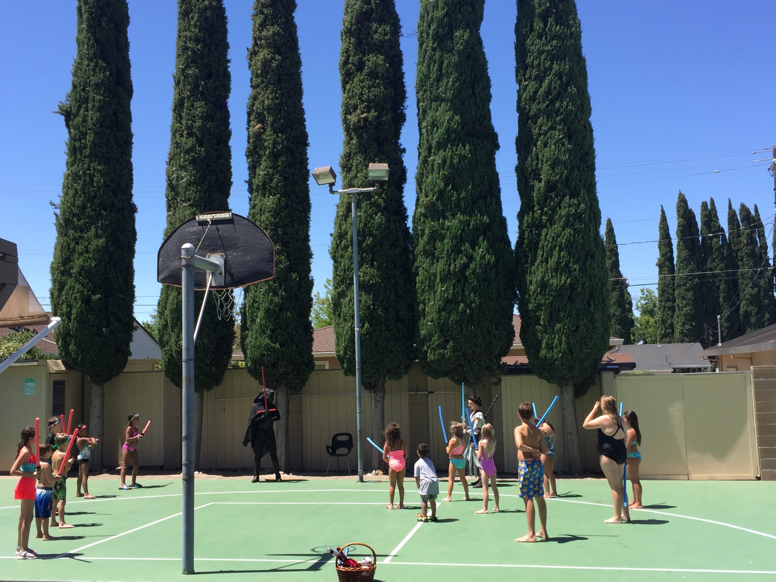 kids playing star wars on the basketball court for the birthday party